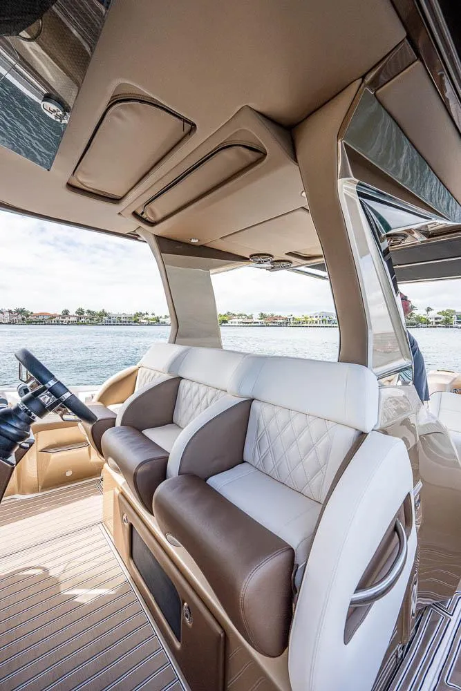 Slide: The Image of 2019 Nor-Tech 450 Sport Center Console interior with luxurious seating and waterfront view. - 6