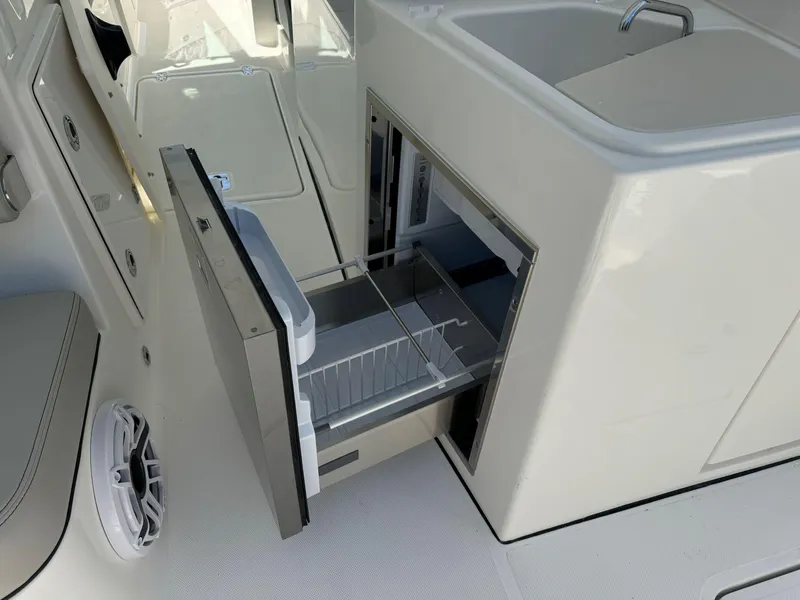 Slide: The Image of 2025 Pursuit DC 326 boat docked at marina under clear sky. - 10