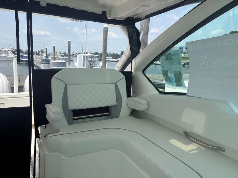 Slide: The Image of 2025 Pursuit DC 326 boat cockpit with steering wheel and control panel, docked at marina. - 18