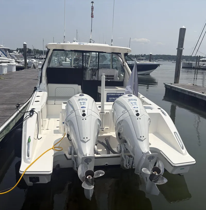 Slide: The Image of 2025 Pursuit DC 326 Dual Console boat cruising on sparkling water. - 2