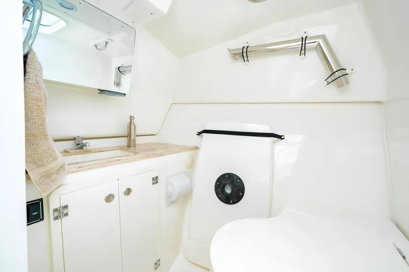 Slide: The Image of 2025 Pursuit DC 326 boat bathroom with sink, mirror, and storage cabinets. - 26