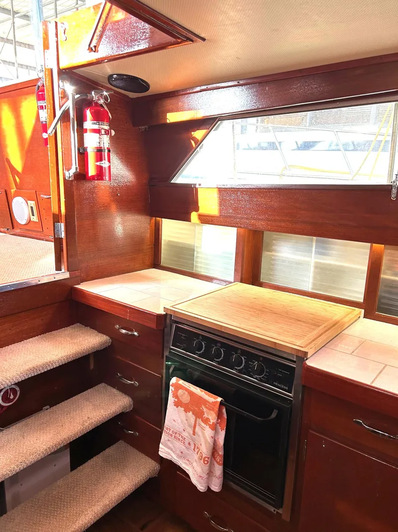 Slide: The Image of 1967 Chris-Craft 38 Commander interior kitchen with wooden cabinetry and stove. - 7