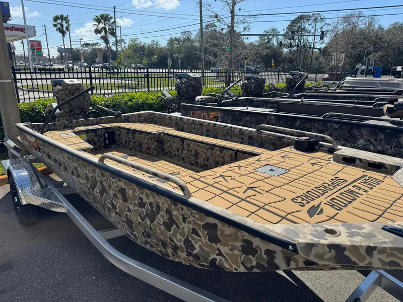 Slide: The Image of 2025 Excel 1860 F4 Shallow Water boat with camouflage design on a trailer. - 2