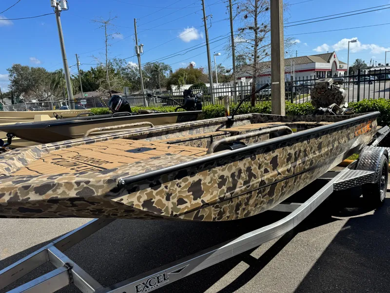 Slide: The Image of 2025 Excel 1860 F4 Shallow Water boat with camouflage design on a trailer. - 29