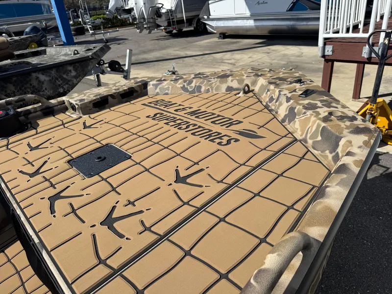 Slide: The Image of 2025 Excel 1860 F4 Shallow Water boat with camouflage design at a marina. - 4