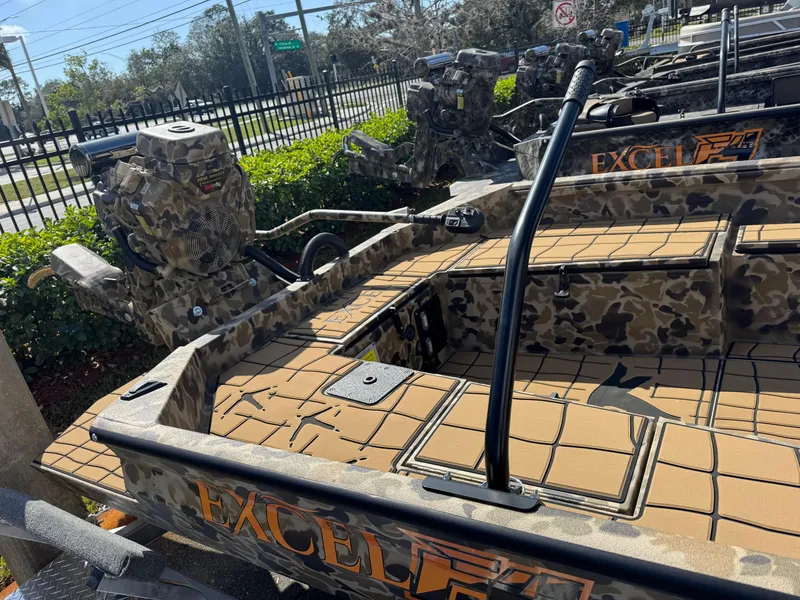 Slide: The Image of 2025 Excel 1860 F4 Shallow Water boat with camouflage design, parked outdoors. - 7