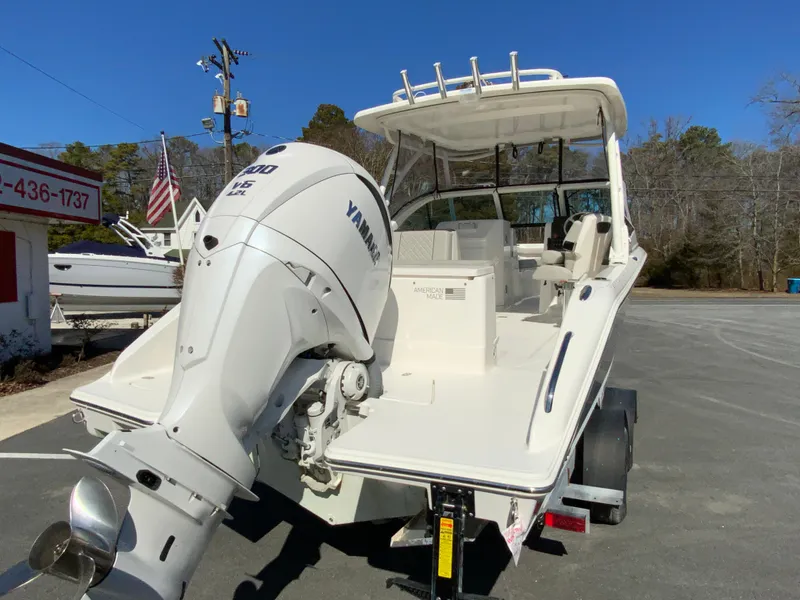 Slide: The Image of 2024 Pursuit DC 246 Dual Console boat with Yamaha outboard motor, parked outdoors. - 10