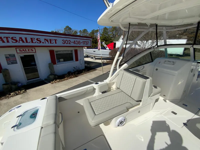 Slide: The Image of 2024 Pursuit DC 246 Dual Console boat with seating, near a sales office. - 14
