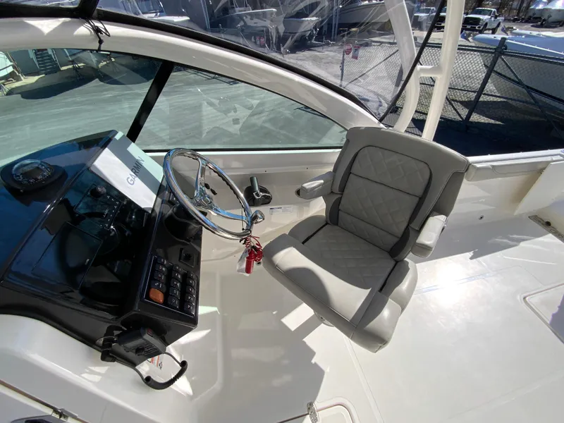 Slide: The Image of 2024 Pursuit DC 246 Dual Console boat interior with steering wheel and captain's chair. - 21