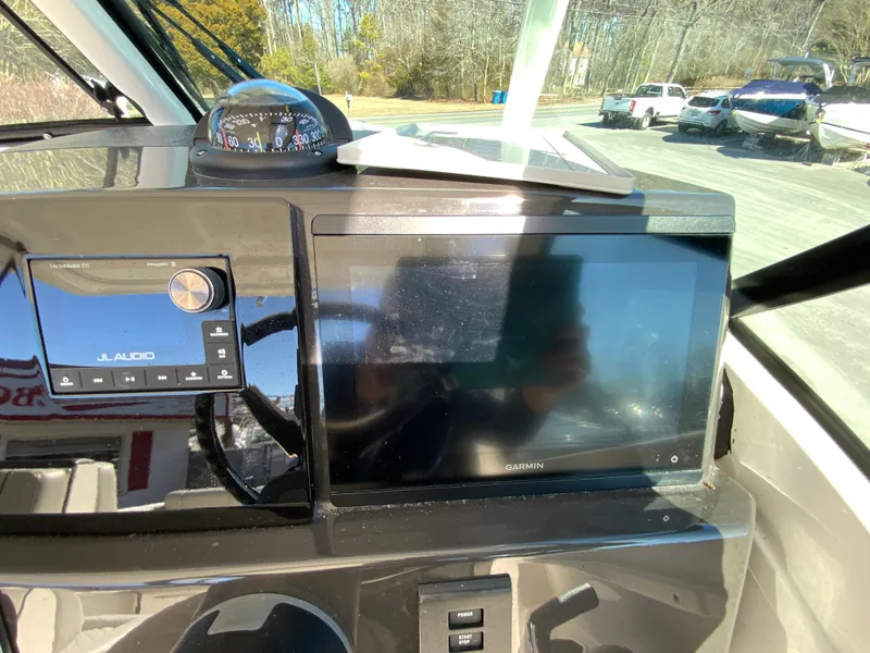 Slide: The Image of 2024 Pursuit DC 246 Dual Console dashboard with Garmin display and JL Audio system. - 23