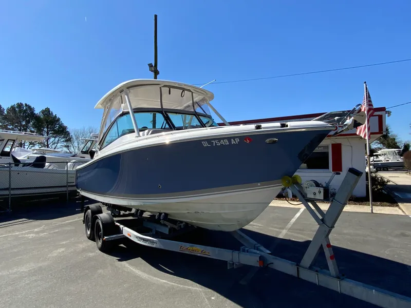 Slide: The Image of 2024 Pursuit DC 246 Dual Console boat on trailer in sunny outdoor setting. - 3