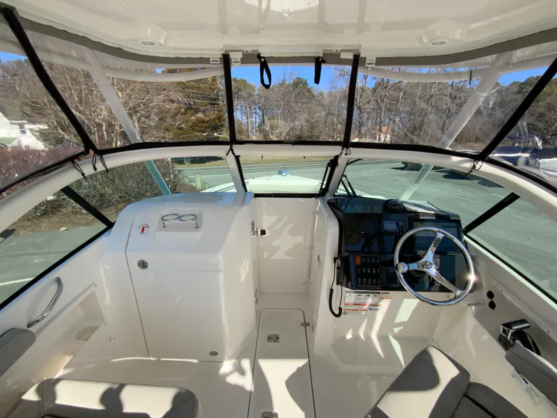 Slide: The Image of 2024 Pursuit DC 246 Dual Console boat interior with steering wheel and dashboard. - 35