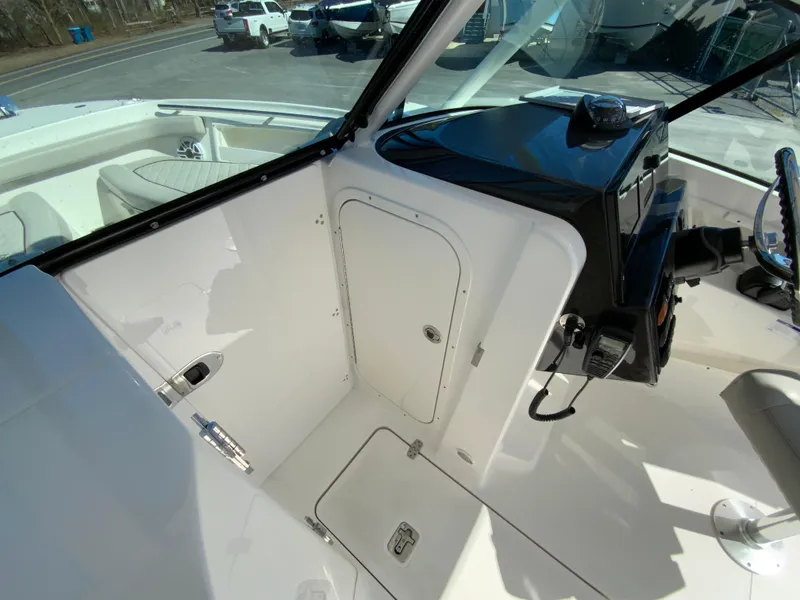 Slide: The Image of 2024 Pursuit DC 246 Dual Console boat interior with helm and storage compartments. - 37