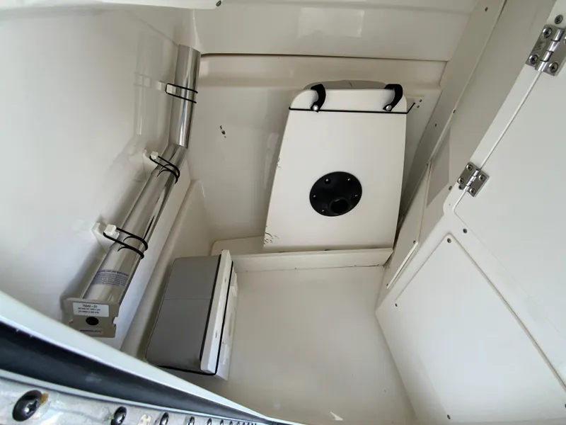 Slide: The Image of 2024 Pursuit DC 246 Dual Console interior storage compartment with white finish and secure fittings. - 38