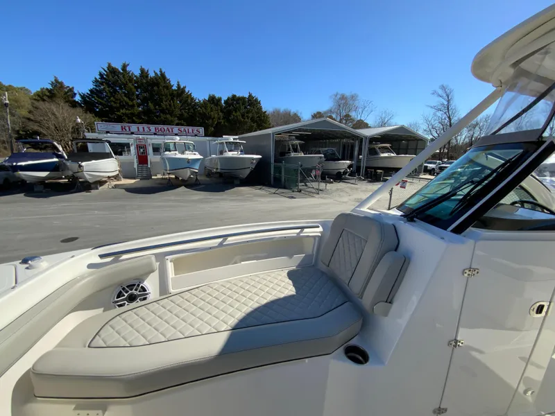 Slide: The Image of 2024 Pursuit DC 246 Dual Console boat at a dealership, featuring spacious seating. - 42