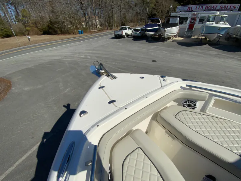 Slide: The Image of 2024 Pursuit DC 246 Dual Console boat at dealership, showcasing bow seating and exterior design. - 46