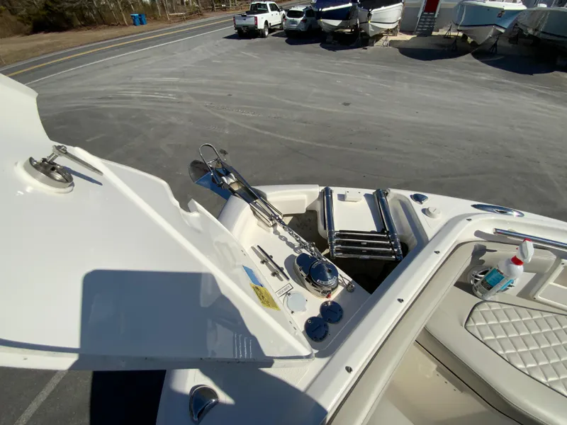 Slide: The Image of 2024 Pursuit DC 246 Dual Console boat, open hatch, docked in a marina. - 48