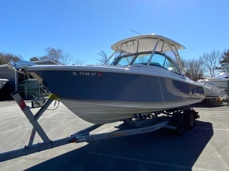 Slide: The Image of 2024 Pursuit DC 246 Dual Console boat on trailer, parked outdoors under clear sky. - 5