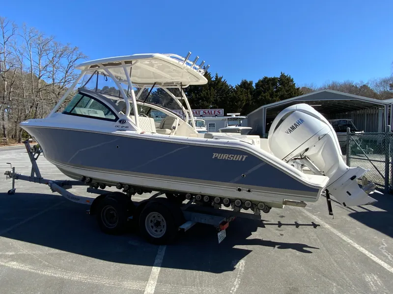 Slide: The Image of 2024 Pursuit DC 246 Dual Console boat on trailer, featuring Yamaha outboard motor. - 7