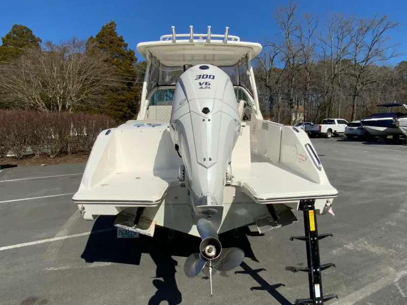 Slide: The Image of 2024 Pursuit DC 246 Dual Console boat with powerful outboard motor, parked outdoors. - 9