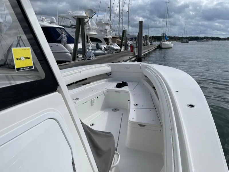 Slide: The Image of 2021 Regulator 28 boat docked at marina, featuring spacious deck and seating area. - 10