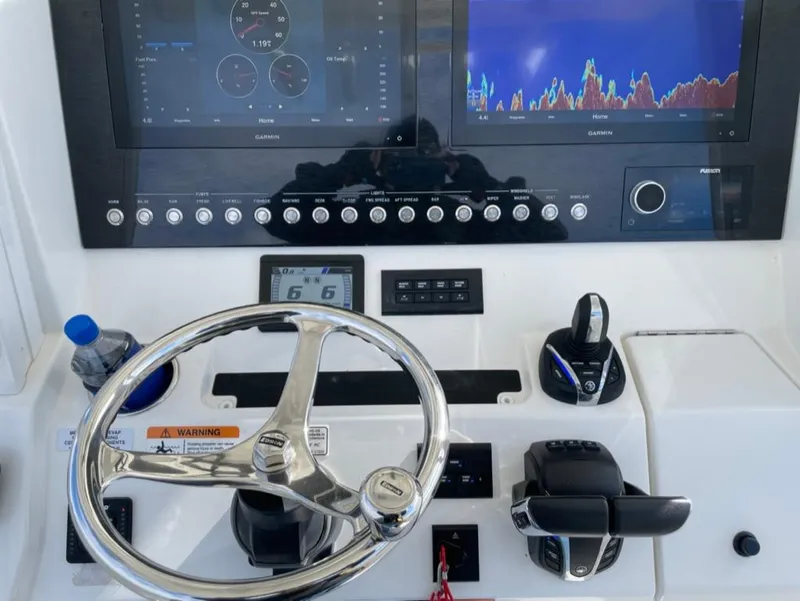 Slide: The Image of 2021 Regulator 28 boat dashboard with steering wheel, controls, and navigation screens. - 3
