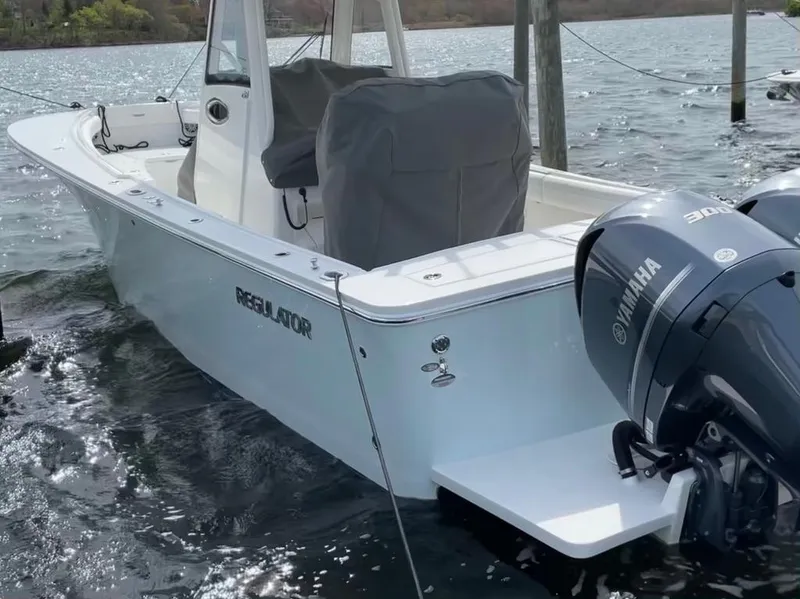 Slide: The Image of 2021 Regulator 28 boat with Yamaha engine docked on water. - 9