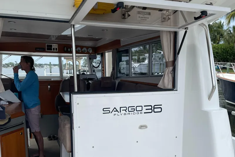 Slide: The Image of 2015 Sargo 36 Flybridge boat interior with person, docked by water. - 21