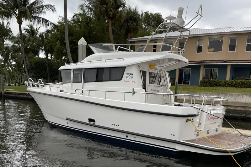 Slide: The Image of 2015 Sargo 36 Flybridge boat docked near palm trees and a building. - 9