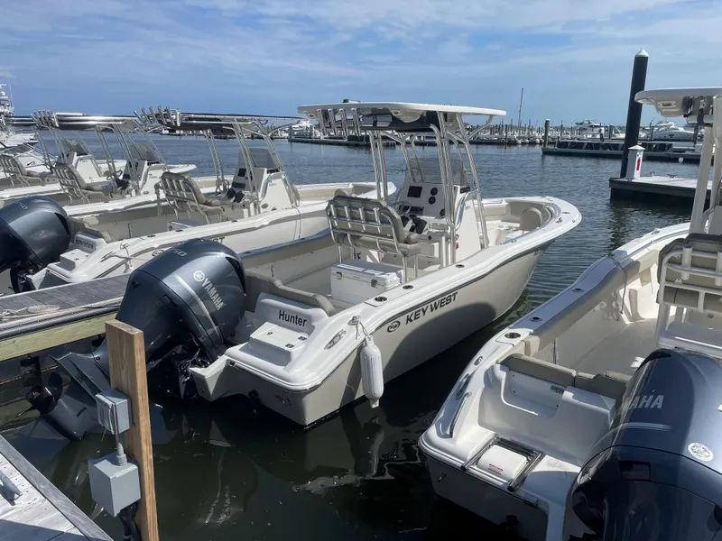 Slide: The Image of 2023 Key West 239 FS boats docked at a marina under a clear sky. - 2