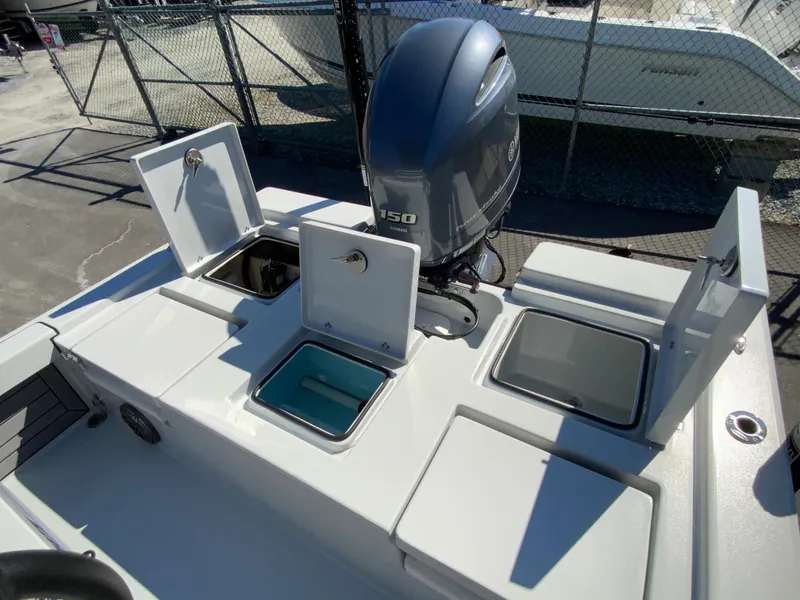 Slide: The Image of 2023 Pathfinder 2200 TRS boat with open storage compartments and outboard motor. - 14