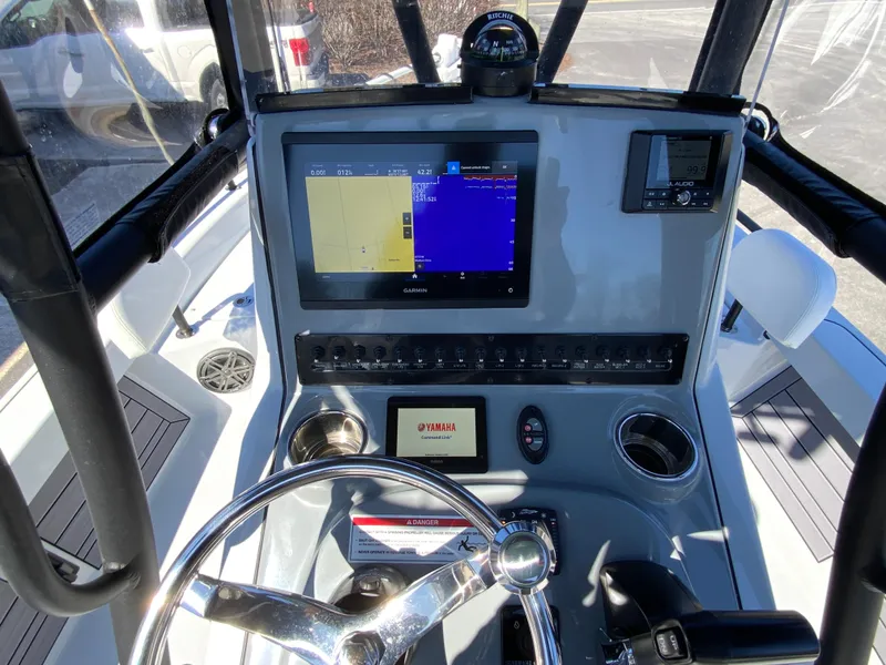 Slide: The Image of 2023 Pathfinder 2200 TRS boat dashboard with navigation screens and steering wheel. - 22