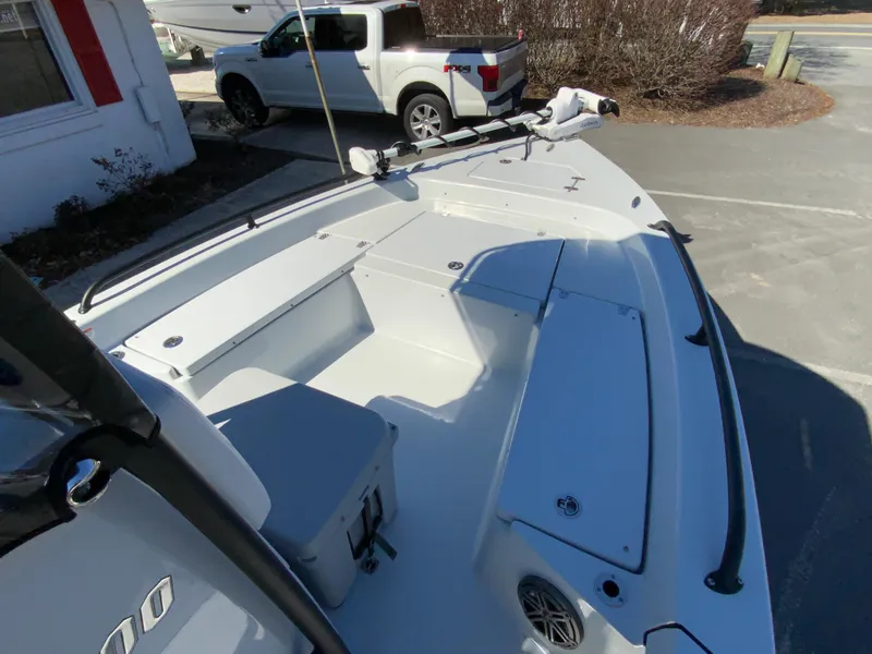 Slide: The Image of 2023 Pathfinder 2200 TRS boat interior with seating and storage, parked near a pickup truck. - 32