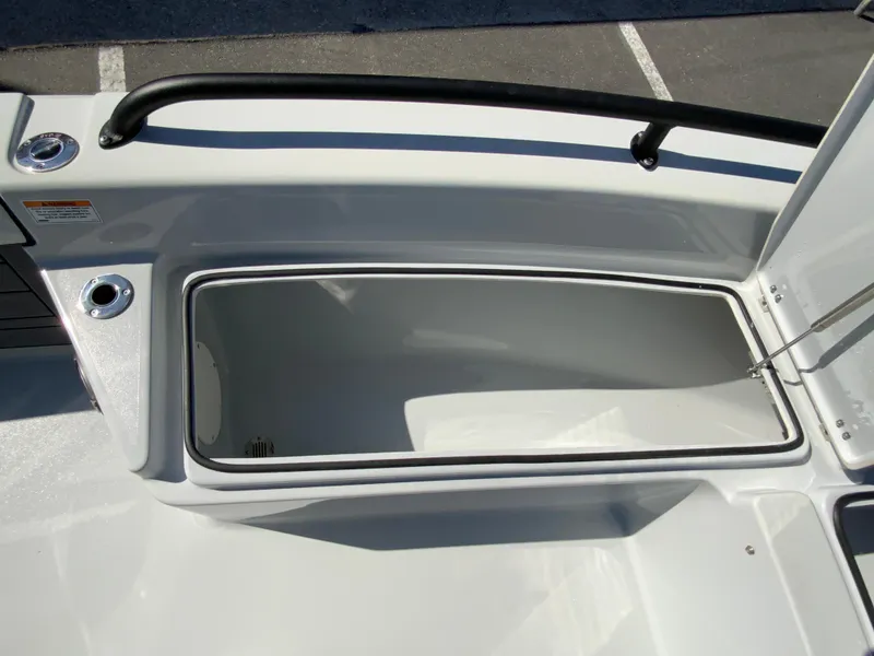 Slide: The Image of 2023 Pathfinder 2200 TRS boat storage compartment, open and empty, with sleek white interior. - 36