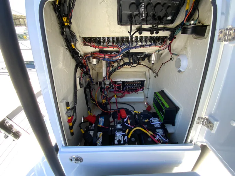 Slide: The Image of 2023 Pathfinder 2200 TRS boat electrical compartment with wiring and battery setup. - 39