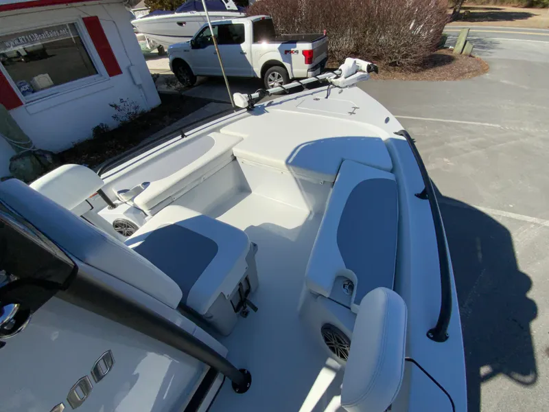Slide: The Image of 2023 Pathfinder 2200 TRS boat interior with seating and console, parked outdoors. - 43