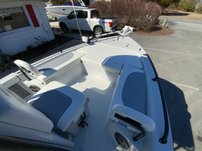 Slide: The Image of 2023 Pathfinder 2200 TRS boat interior with seating and steering wheel, parked outdoors. - 44
