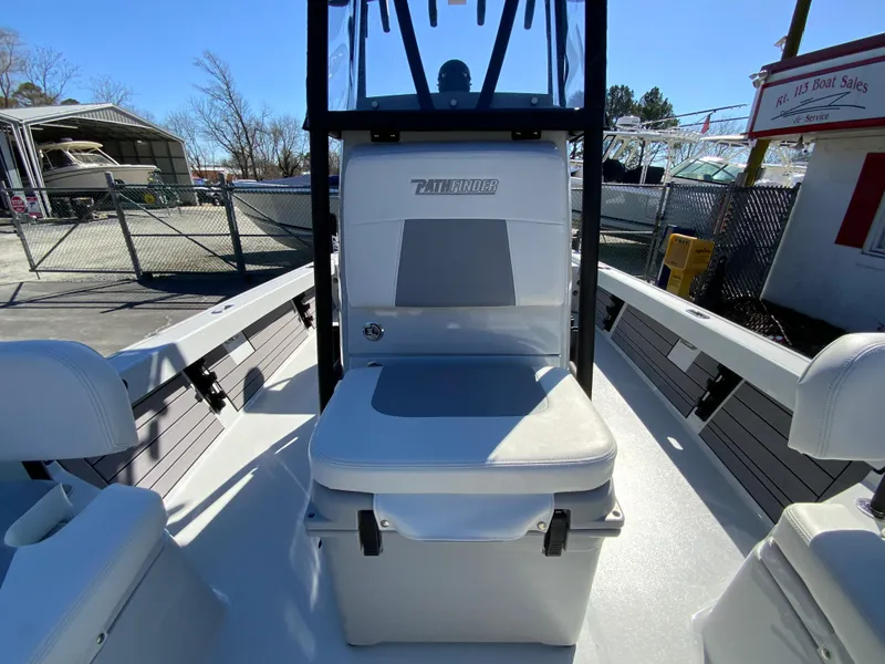 Slide: The Image of 2023 Pathfinder 2200 TRS boat interior with seating and console, in a marina setting. - 46