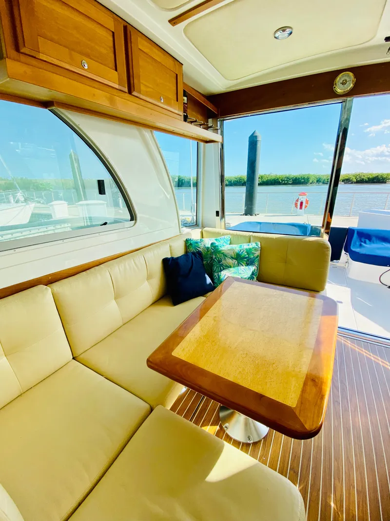 Slide: The Image of Interior of 2014 Back Cove 41 yacht with beige seating and wooden table. - 14