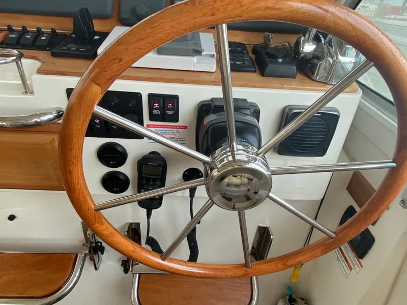 Slide: The Image of Steering wheel of a 2014 Back Cove 41 boat, featuring wooden and metal design. - 27