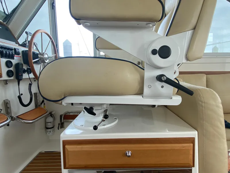 Slide: The Image of Captain's chair and helm of 2014 Back Cove 41 boat, featuring beige upholstery and wooden accents. - 35