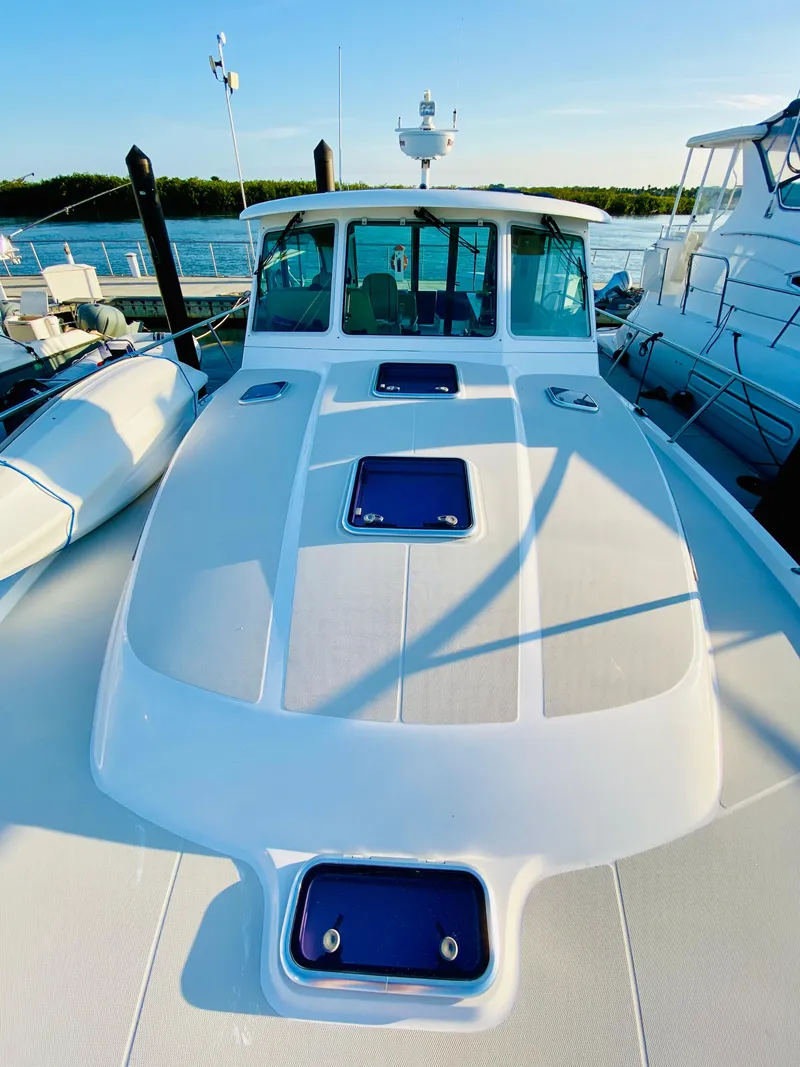 Slide: The Image of 2014 Back Cove 41 yacht docked, showcasing sleek design and spacious deck. - 4