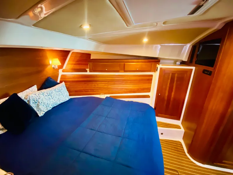Slide: The Image of Luxurious cabin interior of 2014 Back Cove 41 yacht with blue bedding and wooden accents. - 42