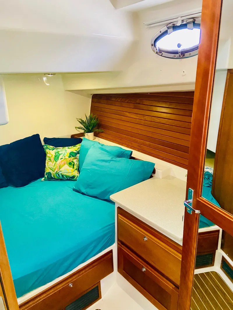 Slide: The Image of 2014 Back Cove 41 cabin interior with teal bedding and wooden accents. - 48