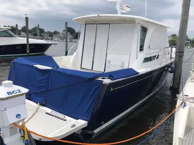 Slide: The Image of 2014 Back Cove 41 yacht docked, featuring a sleek design and blue cover. - 6