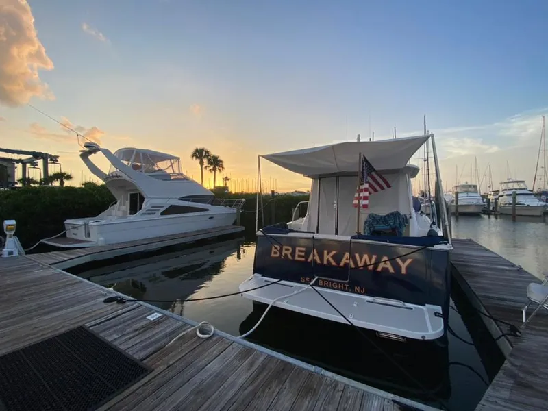 Slide: The Image of Back Cove 41 yacht docked at sunset, featuring "Breakaway" name and American flag. - 9