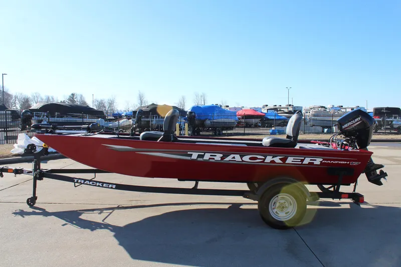 Slide: The Image of 2025 Tracker Panfish 17 boat on trailer, red exterior, parked outdoors. - 5