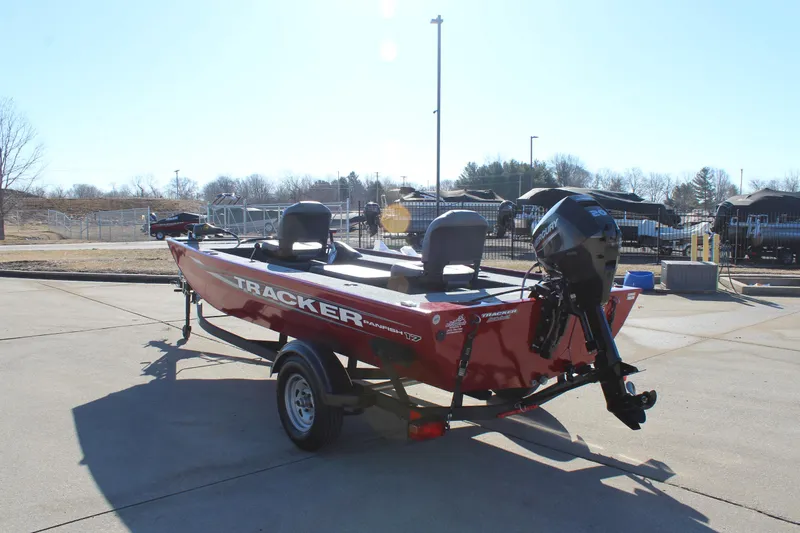Slide: The Image of 2025 Tracker Panfish 17 boat in red, parked on a trailer outdoors. - 6