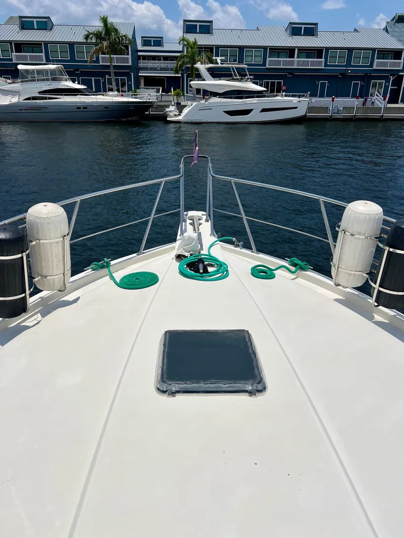 Slide: The Image of Bow view of 1989 Californian 48MY yacht docked near waterfront buildings. - 13