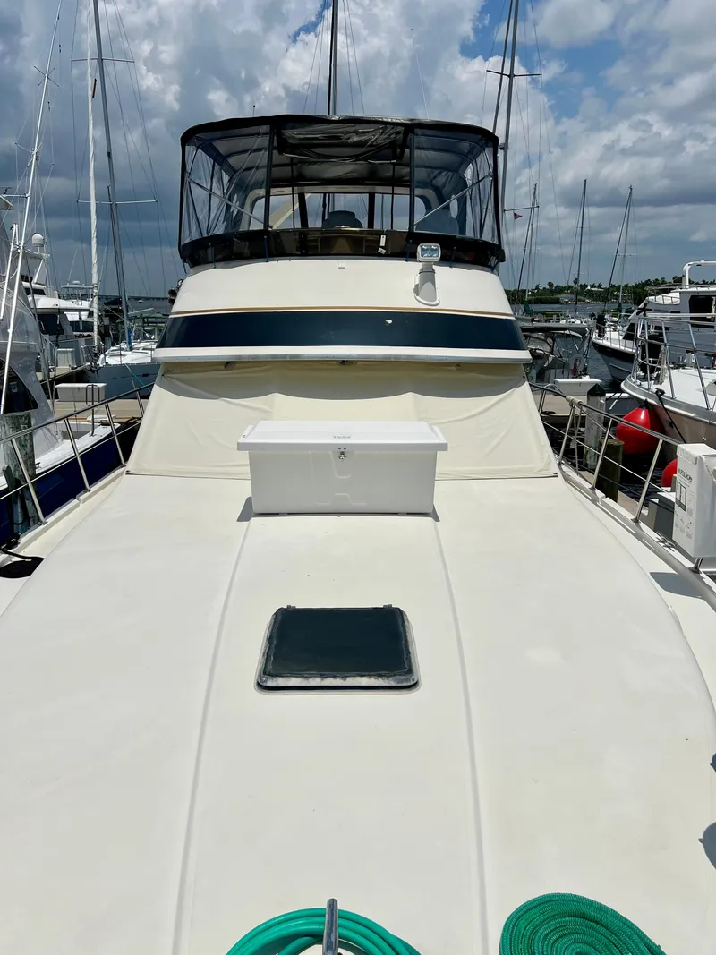 Slide: The Image of 1989 Californian 48MY yacht deck with marina background, clear sky, and moored boats. - 16